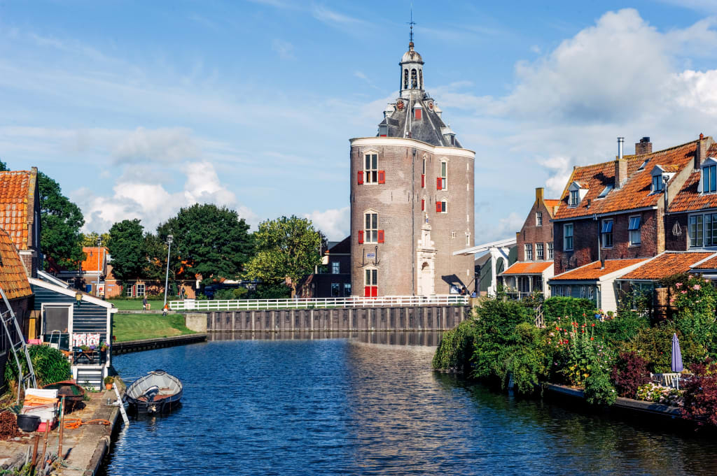 Torre storica con canale e case tradizionali vicino ad Amsterdam.