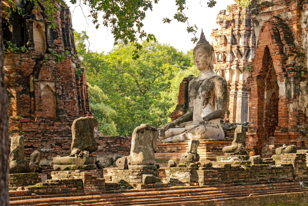 Rovine del tempio Wat Phra Si Sanphet ad Ayutthaya circondate dalla vegetazione.