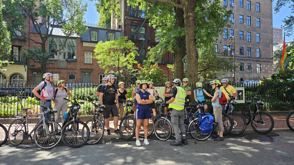Cicloturisti in sosta in un quartiere residenziale di New York durante un viaggio organizzato.