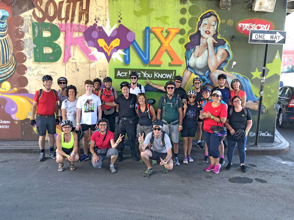 Gruppo di viaggiatori davanti a un murales nel Bronx, quartiere simbolo della cultura urbana di New York.