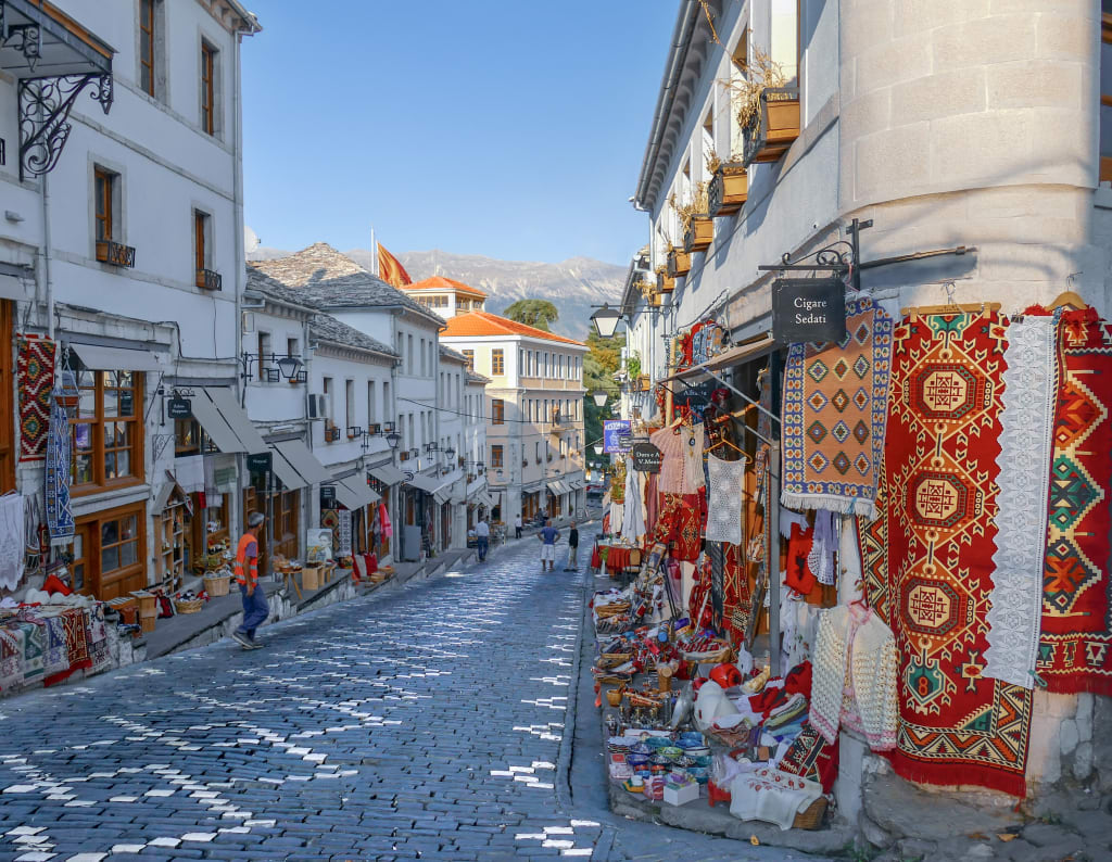 Stradina del centro storico di Gjirokastër con botteghe artigianali nel bazar ottomano, patrimonio UNESCO in Albania