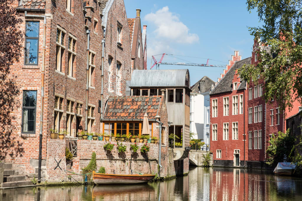 Case sul canale nel centro storico di Bruges, Belgio, con riflessi sull’acqua.