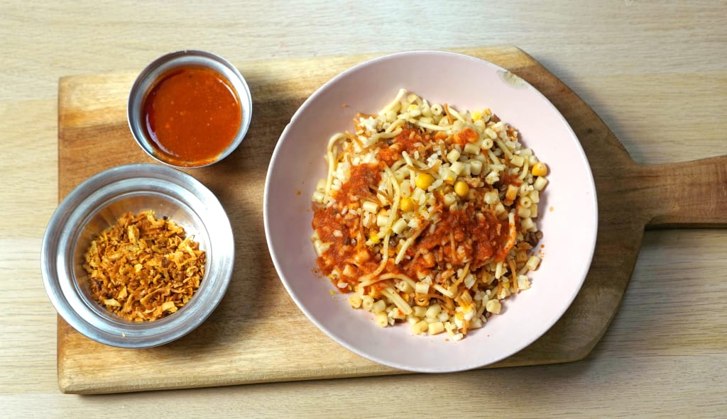 Piatto tradizionale di koshari, specialità della cucina egiziana servita al Cairo.