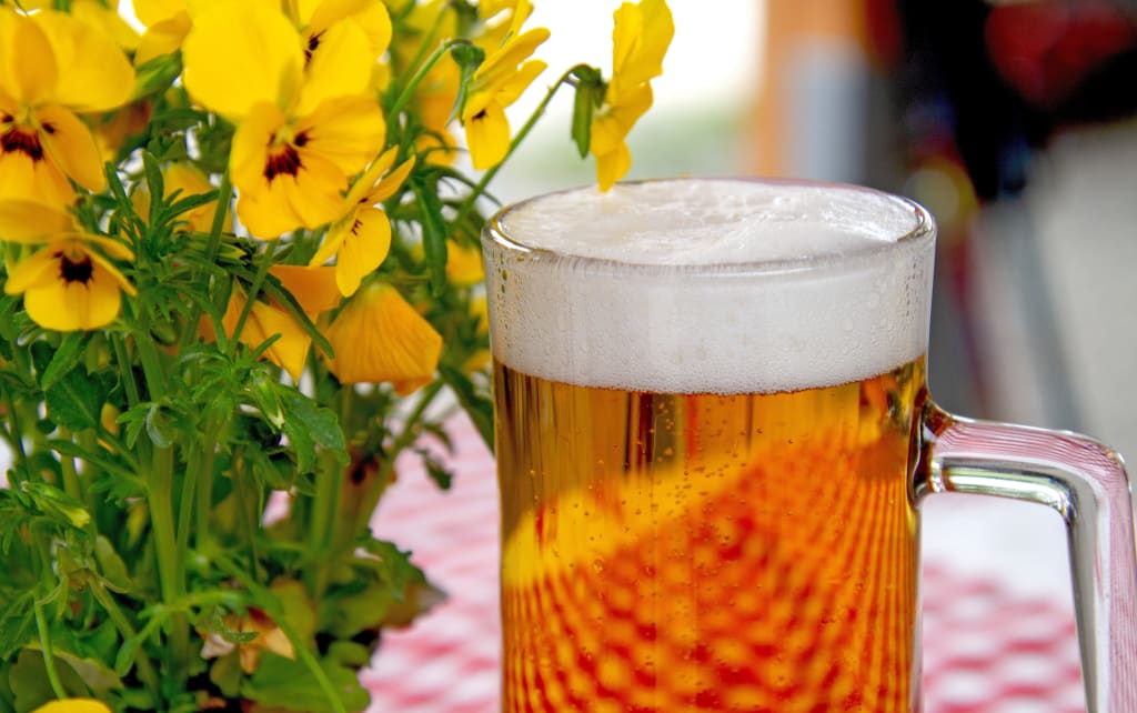 Boccale di birra bavarese con fiori decorativi, simbolo della cultura gastronomica locale.