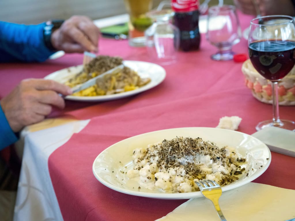 Piatto tipico servito con vino rosso in un locale umbro.