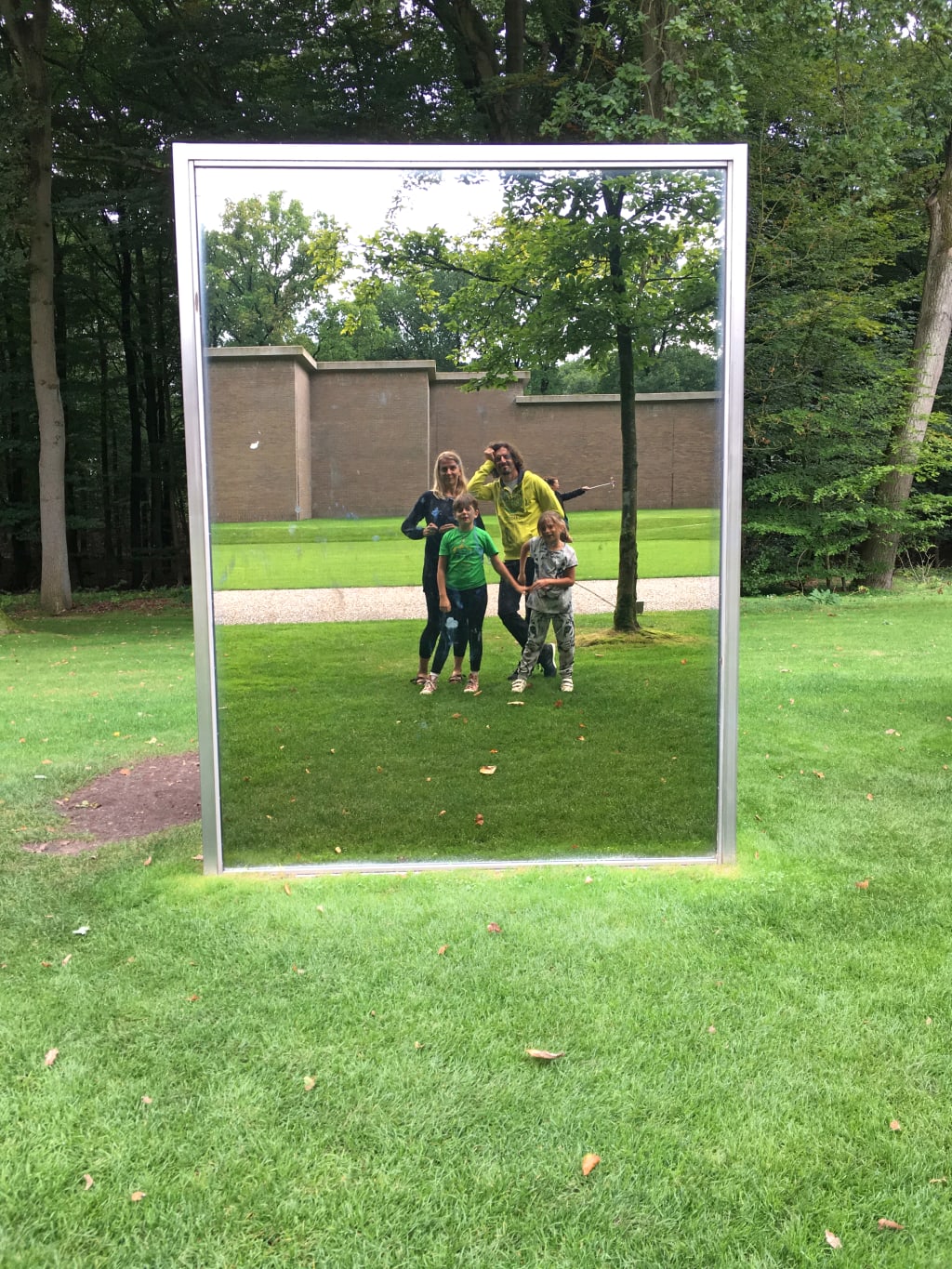 Famiglia fotografata all’interno di una cornice artistica in un parco urbano olandese, esperienza creativa durante una vacanza slow nei Paesi Bassi.