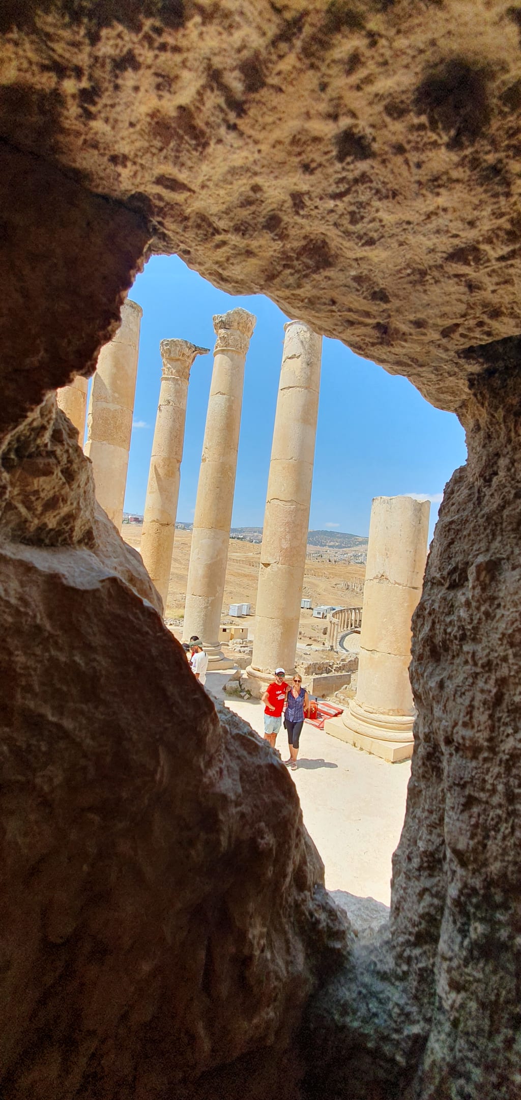 Vista attraverso grotta sulle colonne romane di Jerash, sito archeologico UNESCO in Giordania