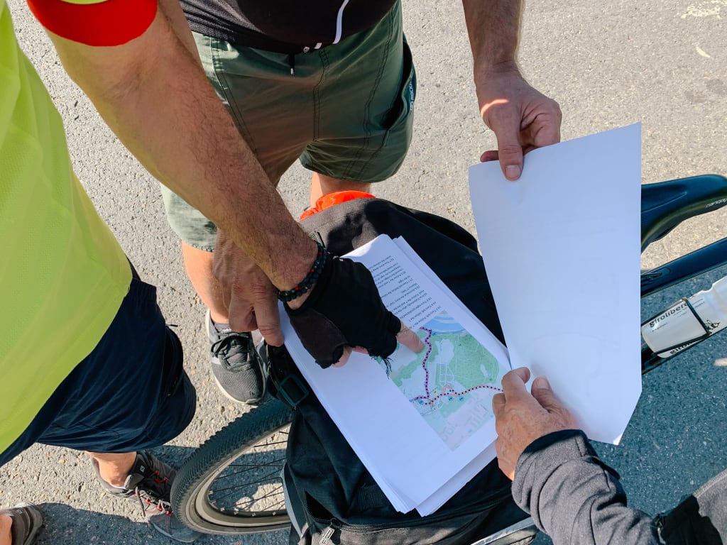 Ciclisti consultano delle cartine con il percorso da seguire