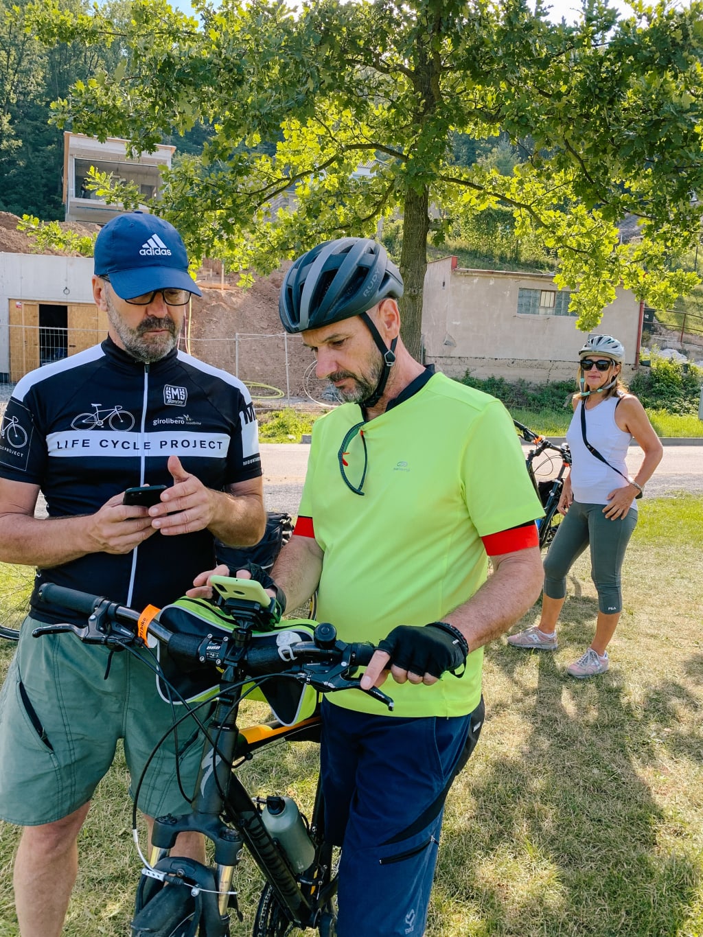 Cicloturisti che consultano la mappa durante un viaggio in bici tra i vigneti della Strada dei Vini d’Alsazia