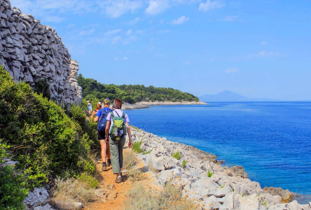 Gruppo escursionisti in cammino lungo la costa di Lussino, Croazia, trekking con "Girolibero"