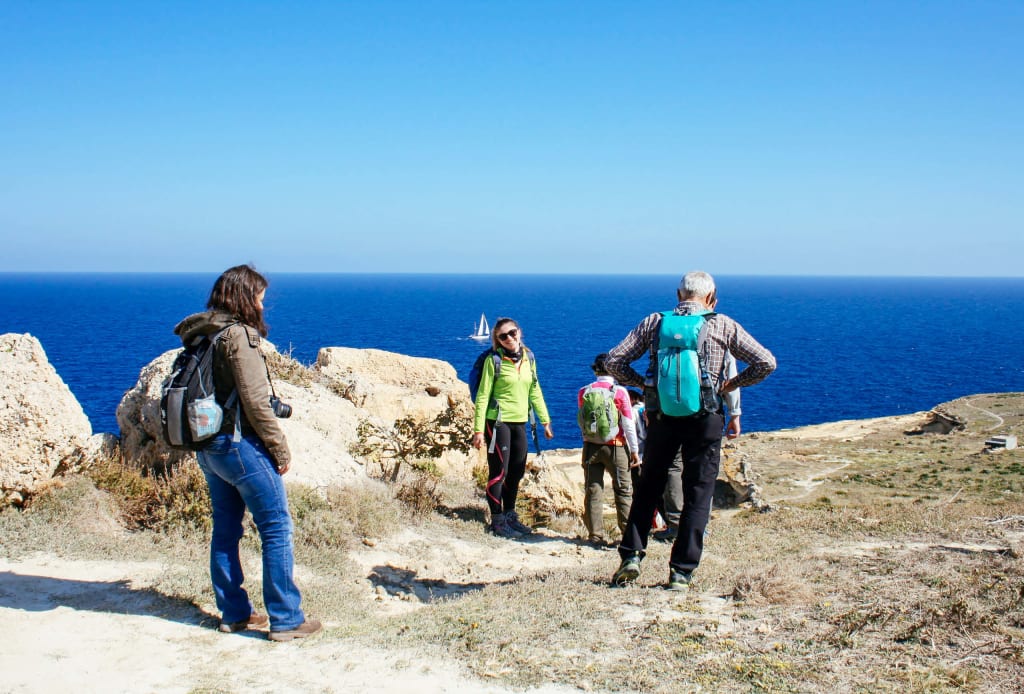 Gruppo di escursionisti su un sentiero lungo la costa, trekking isola di Malta