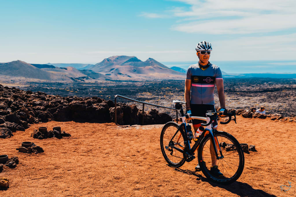 Ciclista in posa su un paesaggio vulcanico a Lanzarote, Canarie.