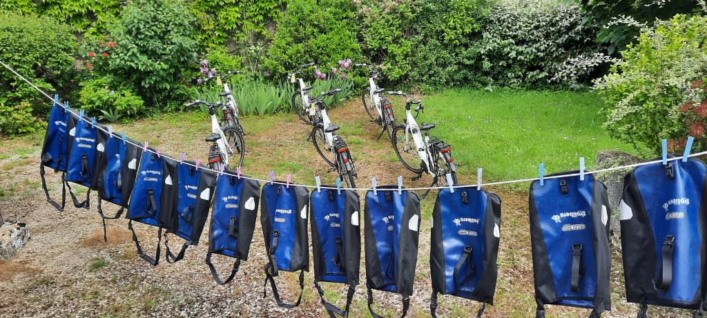 Borse stese ad asciugare ed e-bikes "Girolibero" parcheggiate in un giardino