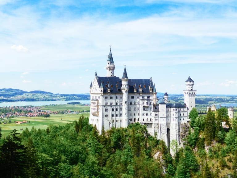 Castello di Neuschwanstein, Baviera, Germania, visto dalla Romantische Strasse, circondato da montagne e foreste.