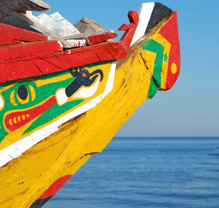Piroga senegalese variopinta ormeggiata, simbolo dei villaggi di pescatori