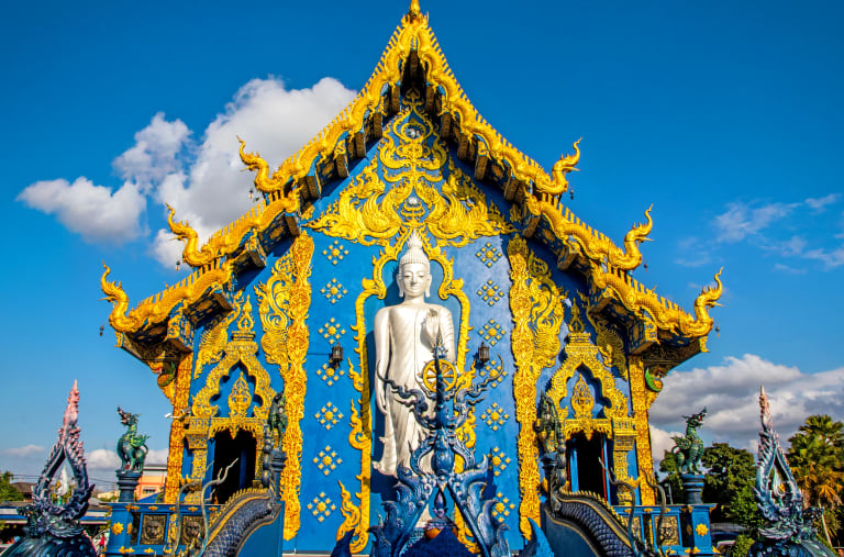 Tempio Blu Wat Rong Suea Ten a Chiang Rai con dettagli dorati e facciata riccamente decorata.