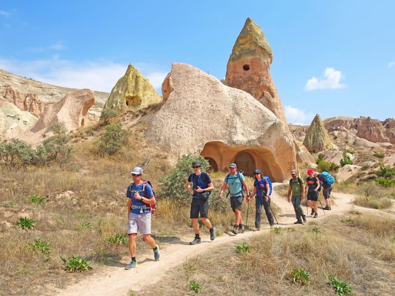 Gruppo di turisti che cammina tra le formazioni rocciose uniche della Cappadocia, viaggio di gruppo 