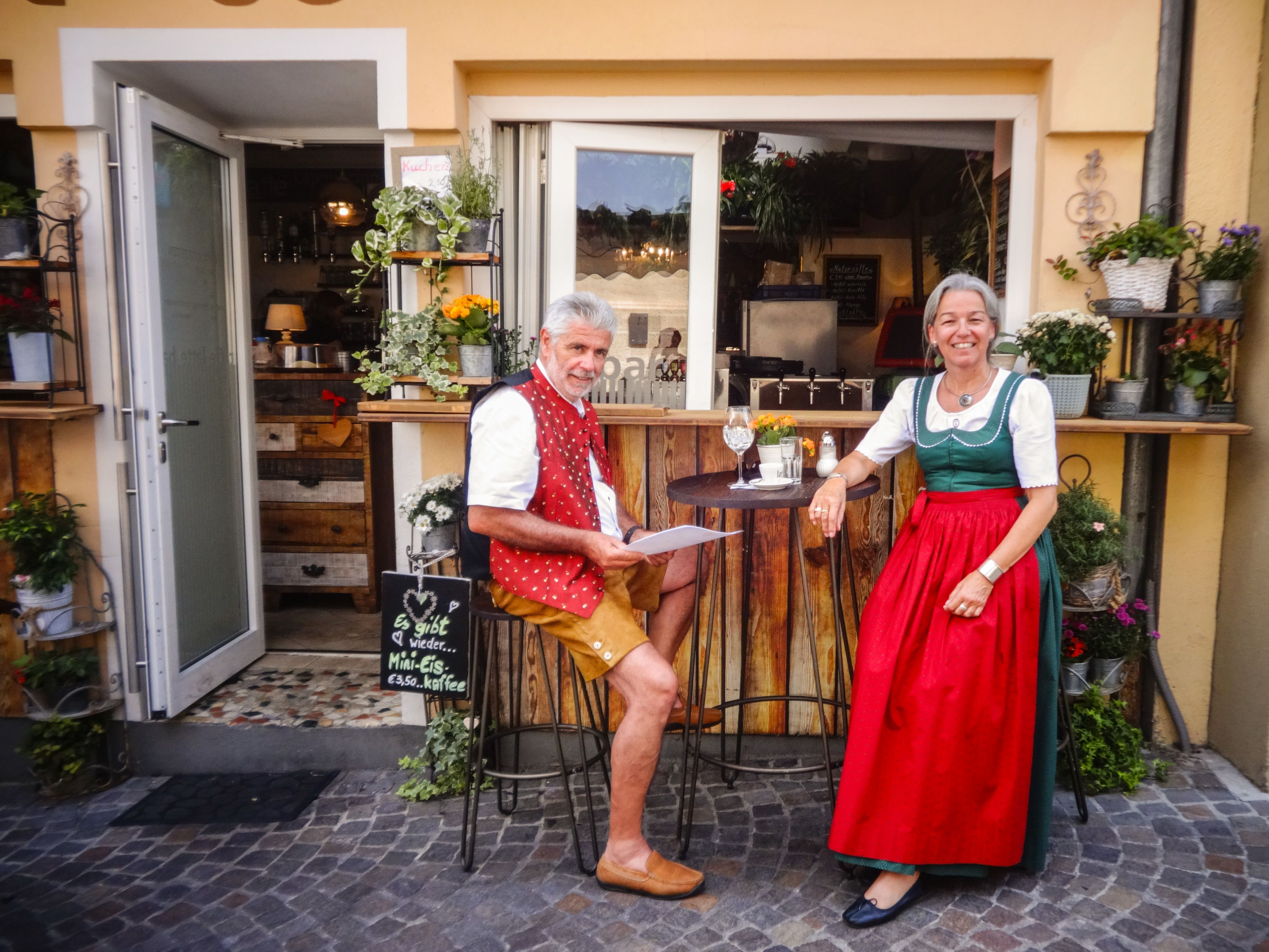 Locale con persone in abiti tradizionali sedute al tavolo fuori, Austria