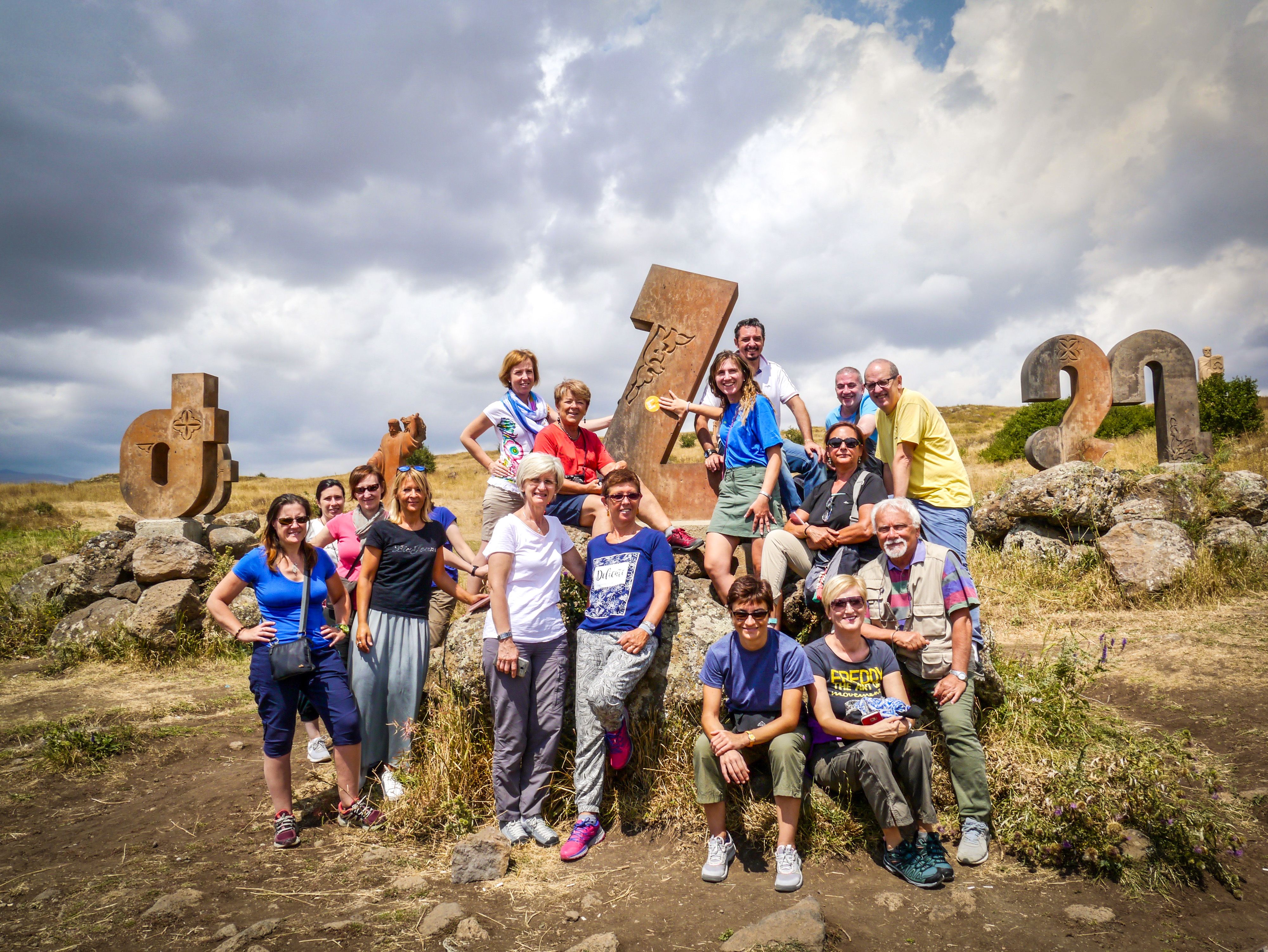 Gruppo di viaggiatori in escursione tra i khachkar, le croci di pietra armene nel sito di Noratus, Armenia.