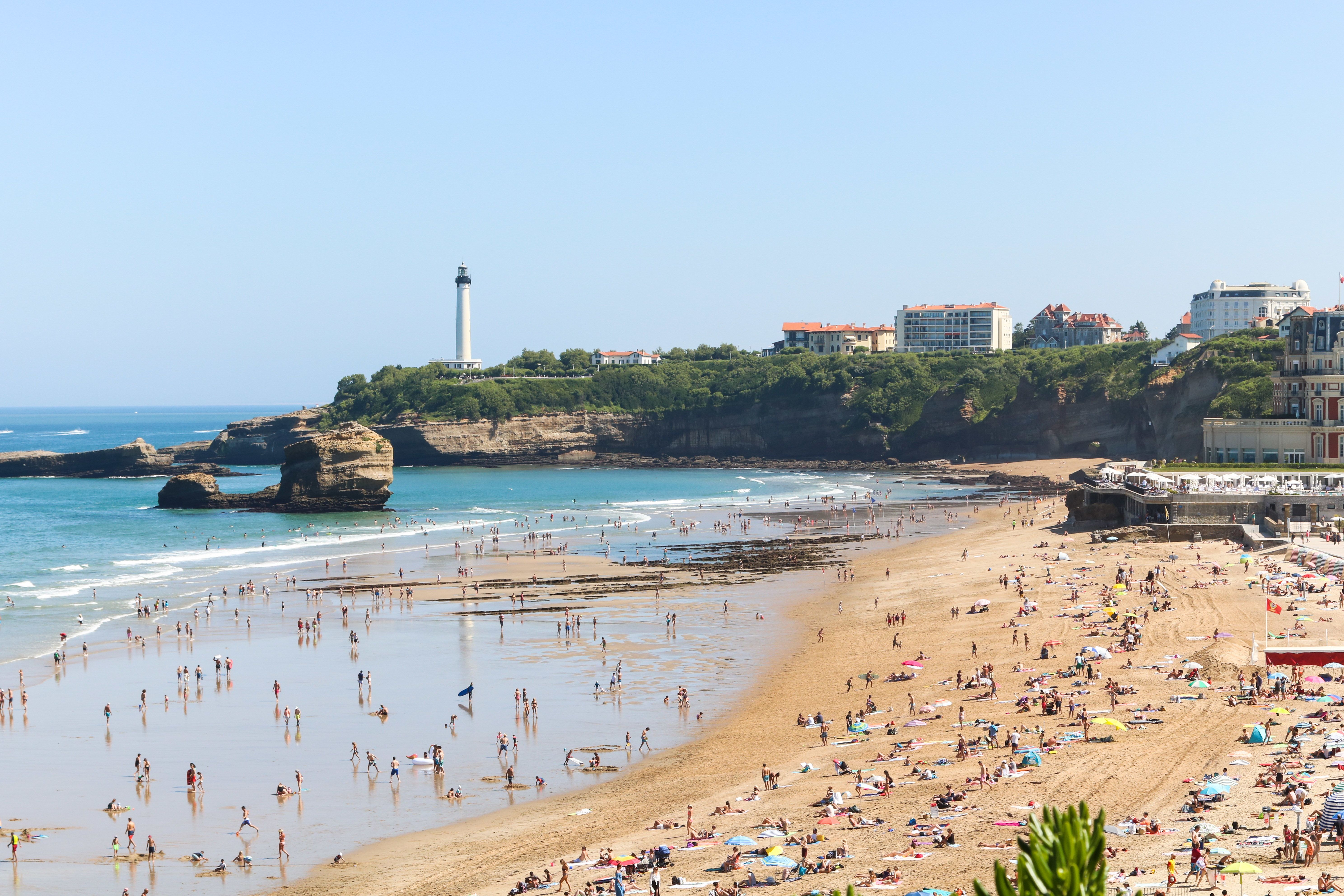 Spiaggia con sabbia dorata e mare calmo, cielo limpido sullo sfondo.