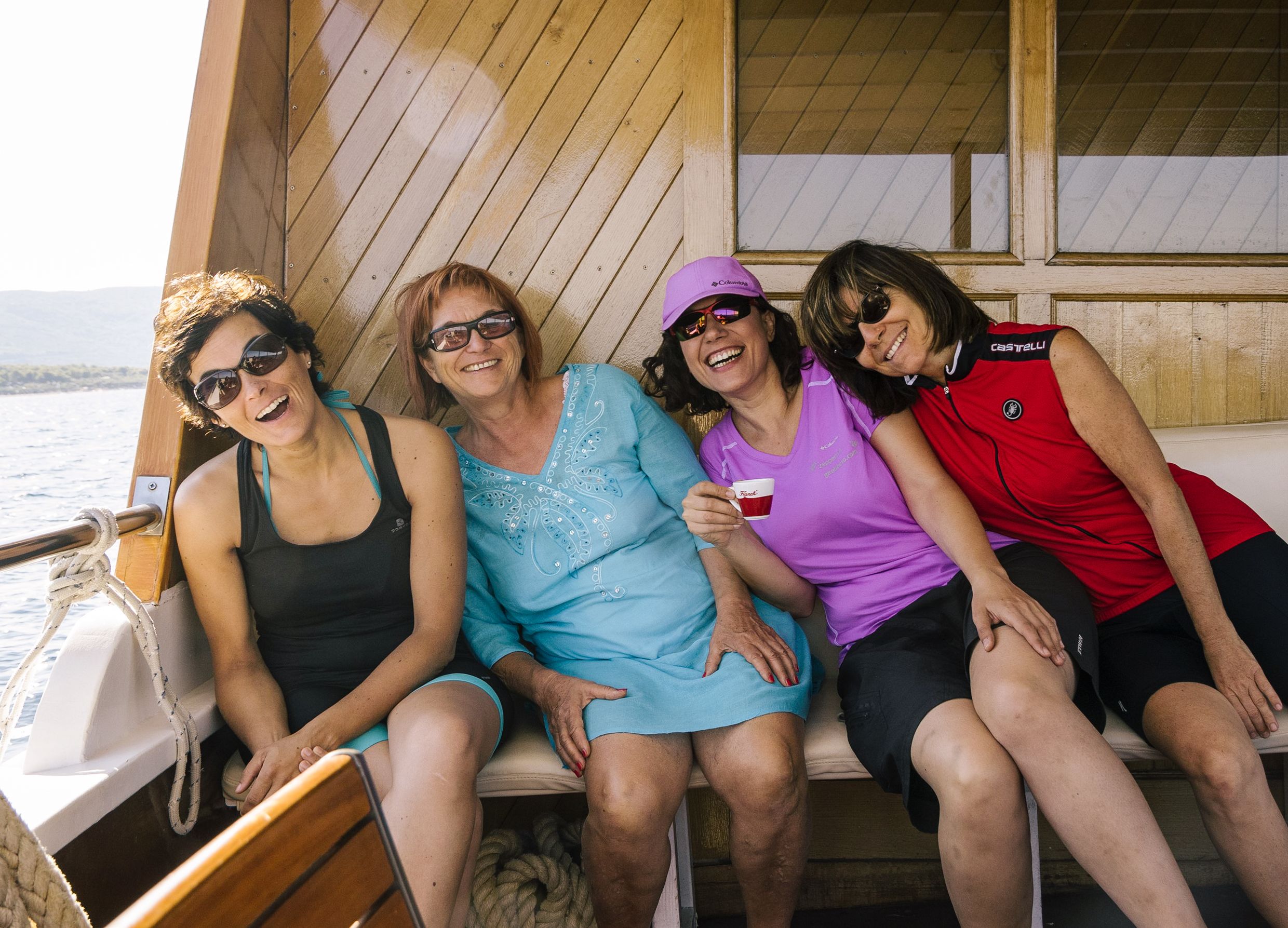 Entspannte Gruppe von Freunden sitzt auf einem Boot, Bootstour in Kroatien.