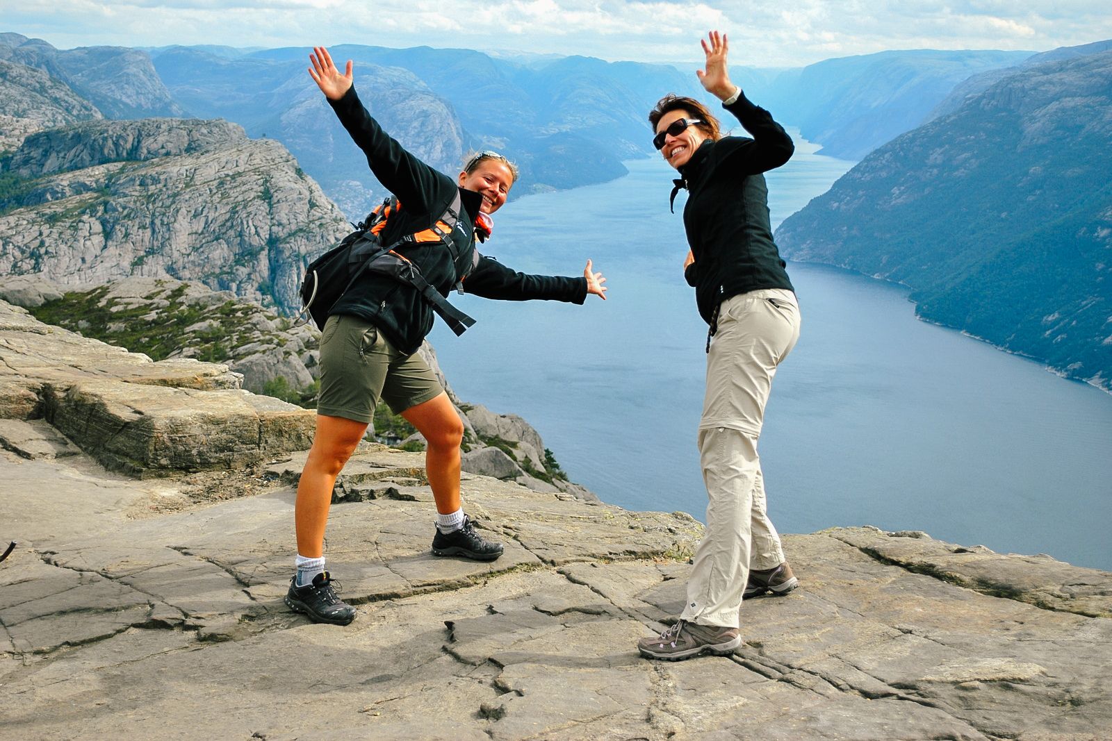 Coppia di turisti in posa su Preikestolen con vista sul Lysefjord, Norvegia