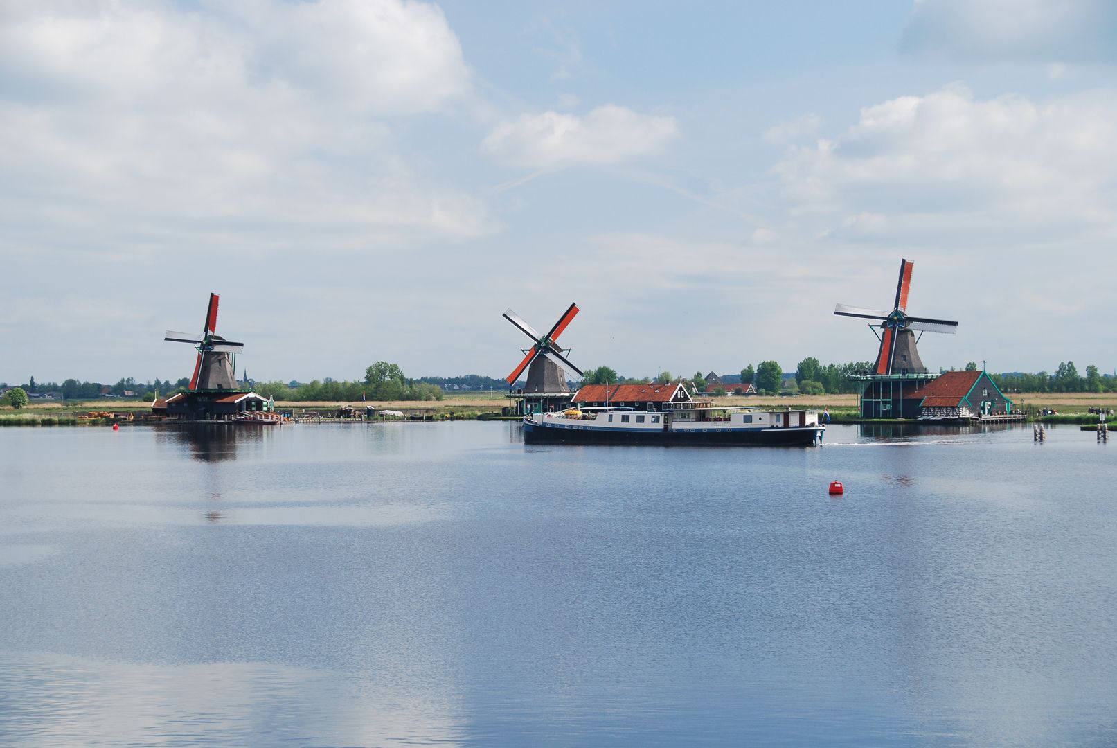 Mulini a vento tradizionali lungo i canali di Kinderdijk, barca in navigazione, vacanze in bici e barca Olanda.