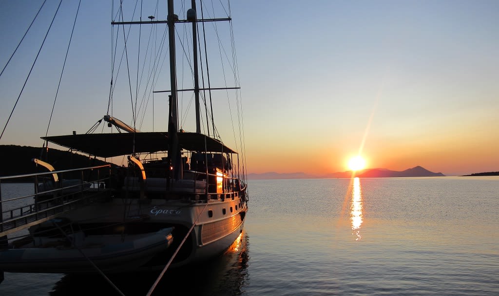 Tramonto sul mare con barca a vela "Erato" ormeggiata nel porto di Atene, Grecia.