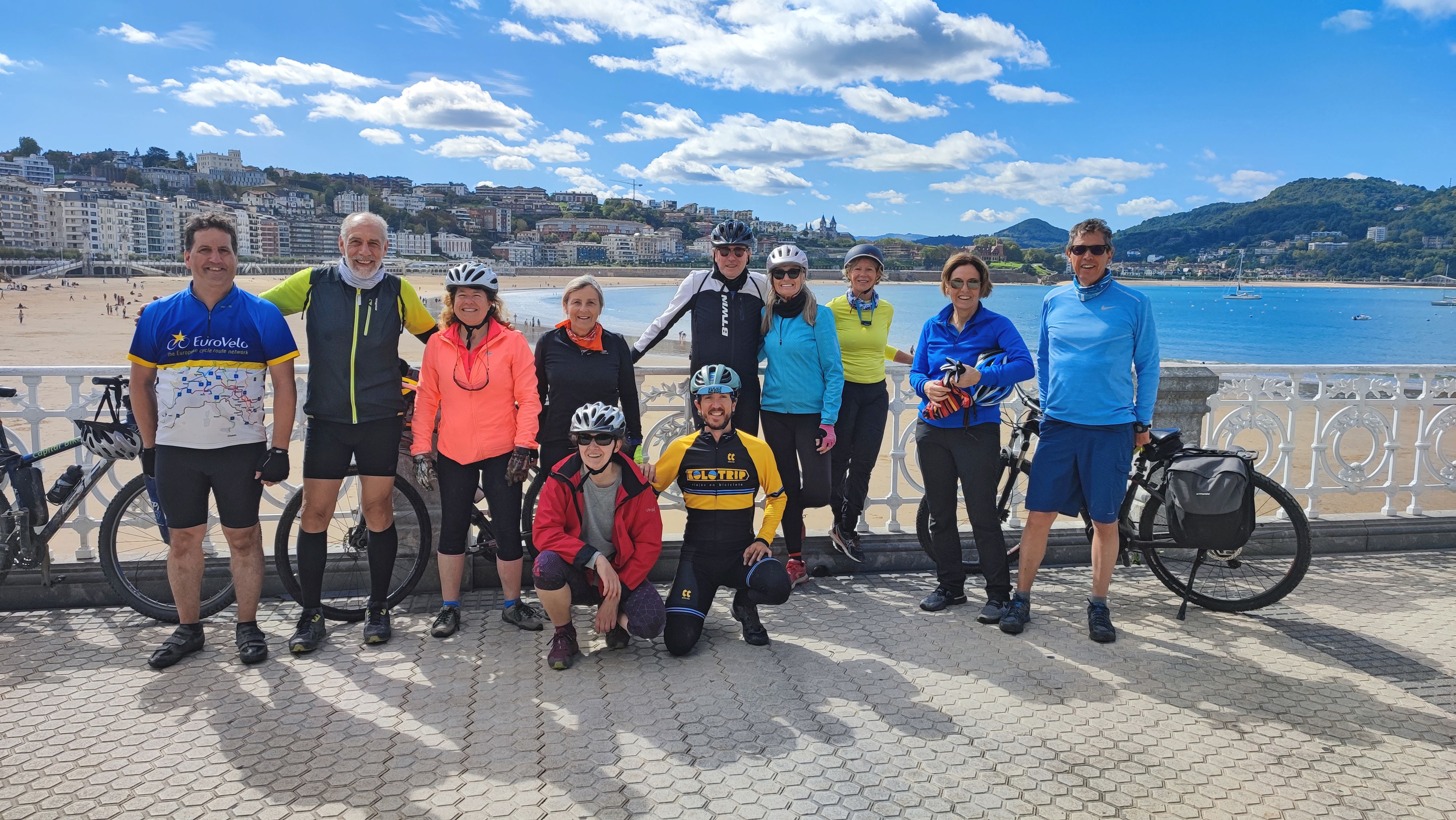 Gruppo di ciclisti in viaggio con "Girolibero" davanti al mare dei Paesi Baschi, città della costa basca