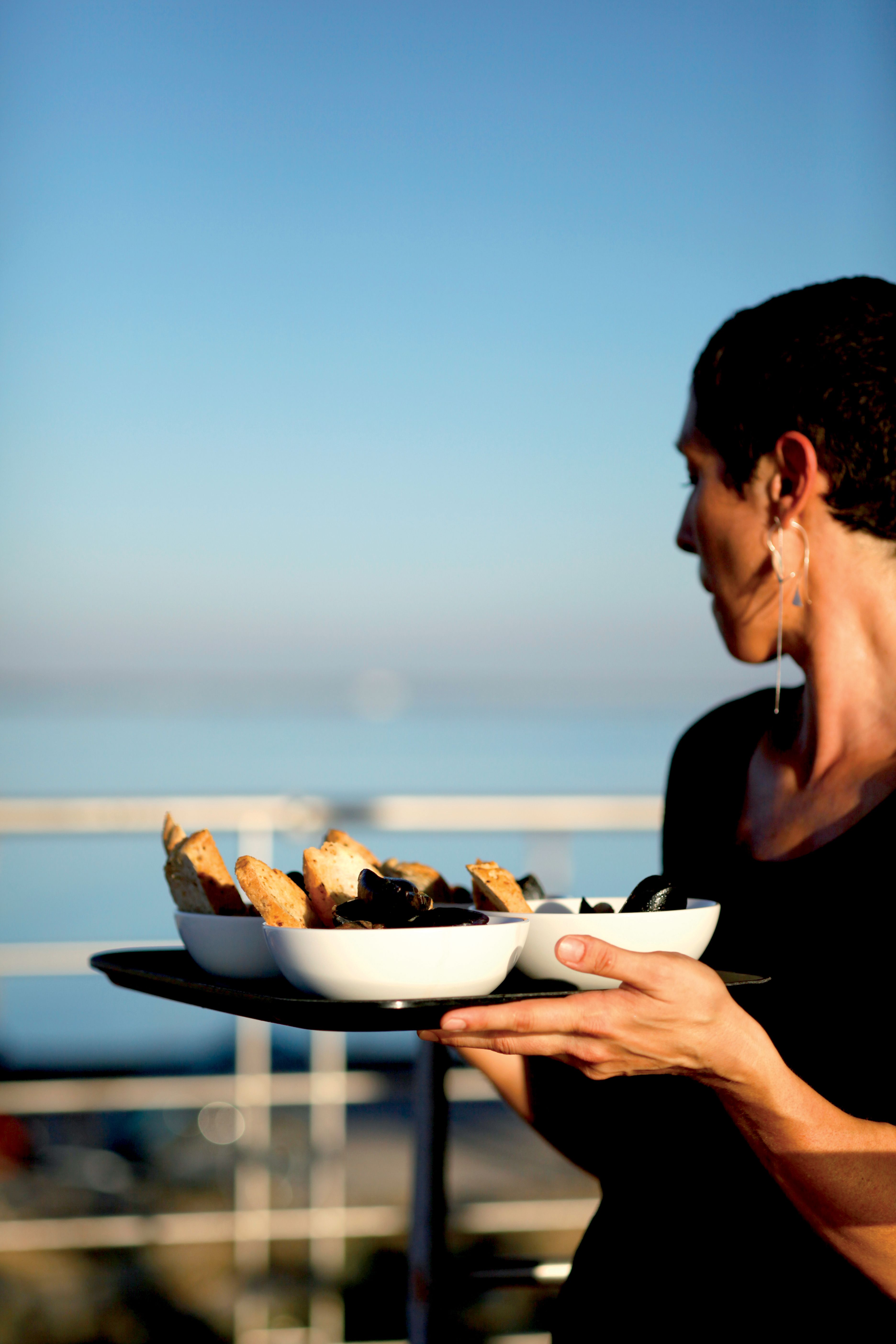 Cameriera che serve piatti su un vassoio, vacanze in barca 