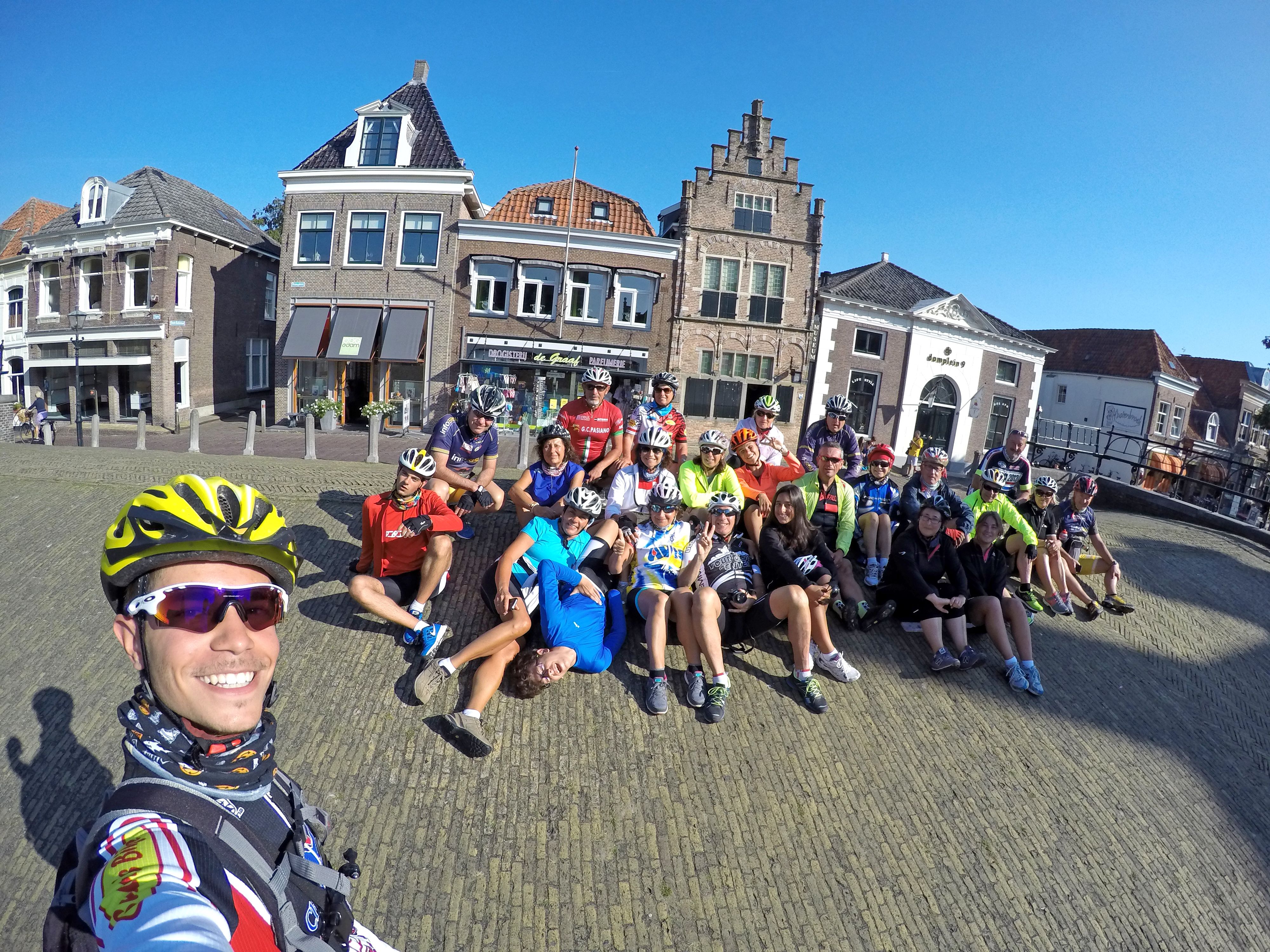 Gruppo di ciclisti in vacanza con Girolibero in piazza con edifici storici, Olanda.