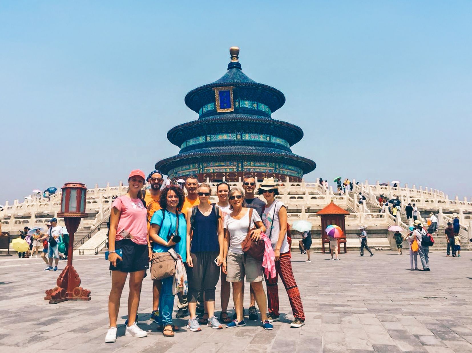 Gruppo di viaggiatori davanti al Tempio del Cielo a Pechino durante una giornata soleggiata.
