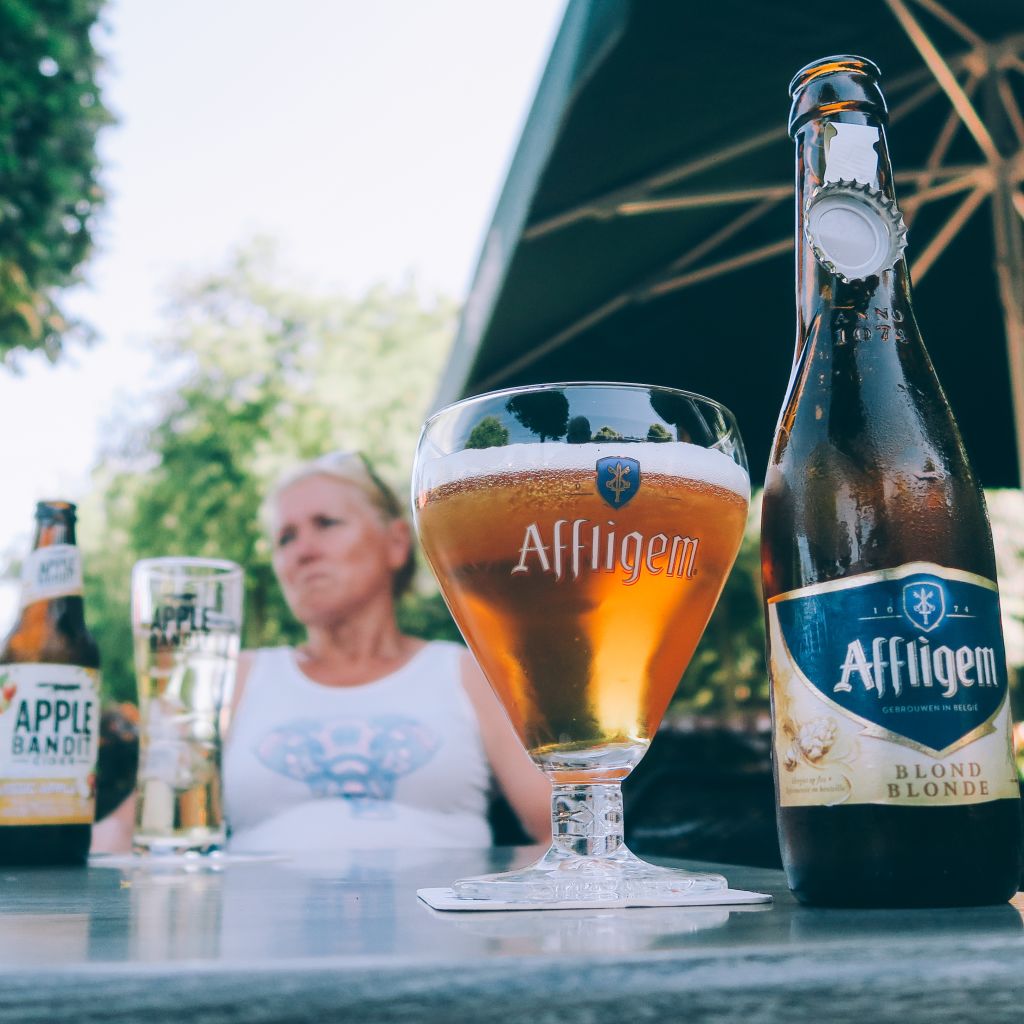 Bierflaschen werden im Freien serviert, während die Leute am Tisch sitzen
