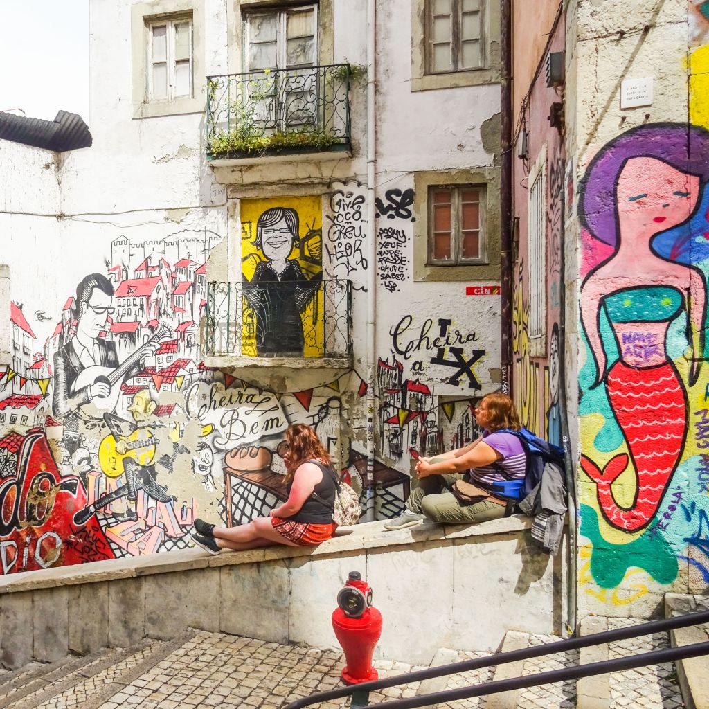 Murales colorati lungo una strada pedonale a Lisbona, Portogallo.