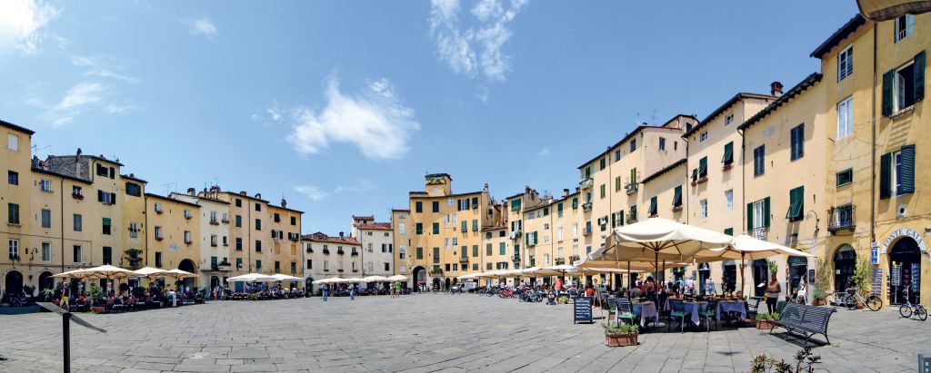 Piazza dell'Anfiteatro, ristoranti e bar con tavolini all'aperto, edifici disposti a forma ellittica, ciclismo, Lucca, Toscana