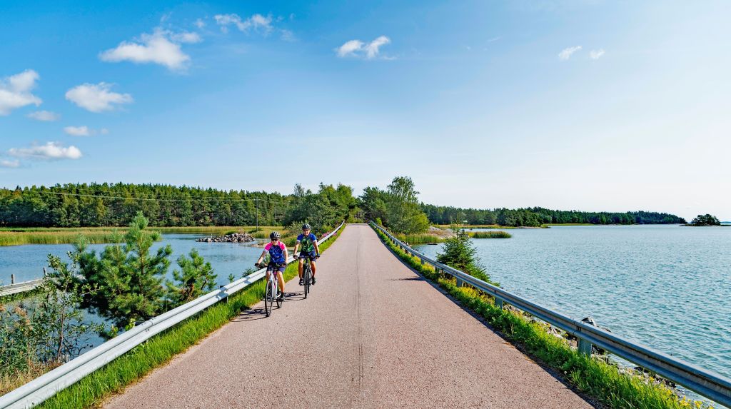 Ciclisti lungo una strada costiera immersa nella natura nell'arcipelago di Turku.