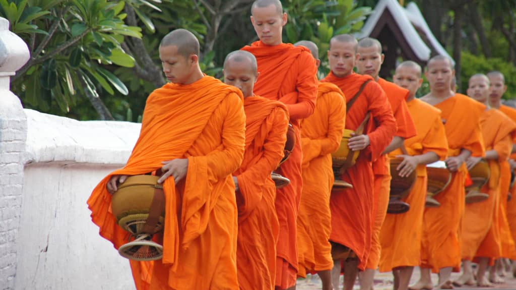 Processione Tak Bat a Luang Prabang – monaci buddisti in vesti arancioni che raccolgono offerte all’alba