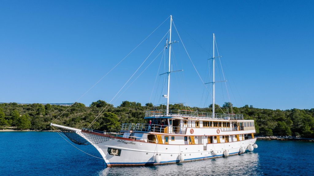 Barca a vela Magellan ormeggiata in una baia tranquilla nel Parco Nazionale di Kornati, Croazia.
