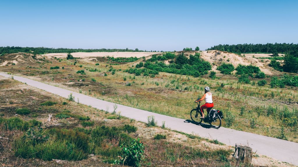 Radfahrer im Urlaub mit "Girolibero" in Holland, Küstenlandschaft mit Dünen und Radweg in den Niederlanden.