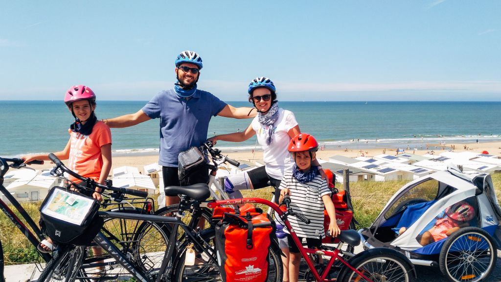 Famiglia in bici davanti alla costa con vista sul mare, Olanda in bici per famiglie