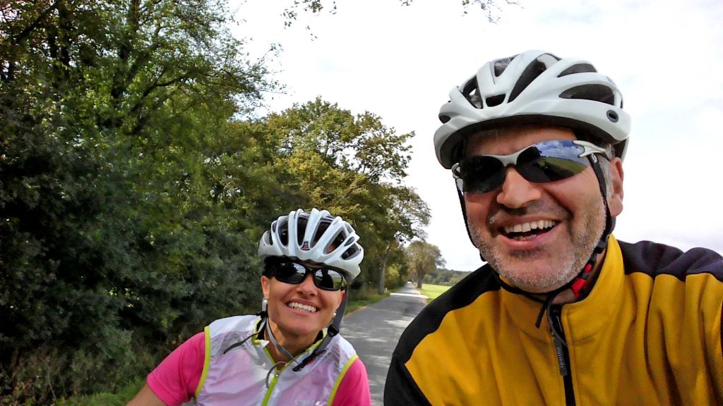 Coppia di ciclisti sorridenti con casco, lungo il percorso da Berlino al Baltico