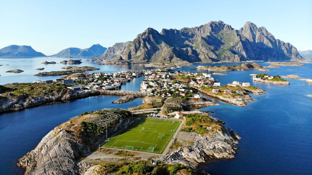 Vista aerea di un villaggio costiero con montagne circostanti e acqua cristallina, Lofoten