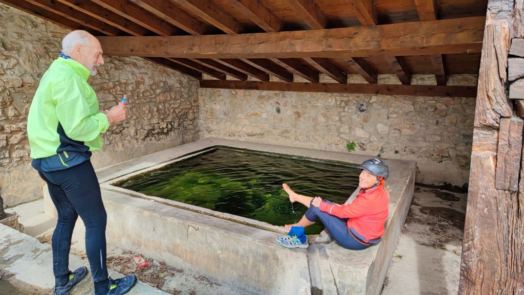 Pellegrini presso un antico lavatoio lungo il Cammino di Santiago in Navarra, Spagna.