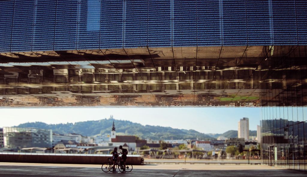 Copia di cicloturisti fermi sotto al Lentos Art Museum, museo d'arte moderna di Linz, Austria