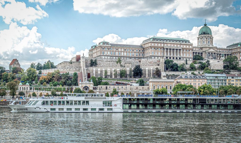 Nave da crociera fluviale in navigazione sul Danubio con la città storica di Budapest sullo sfondo