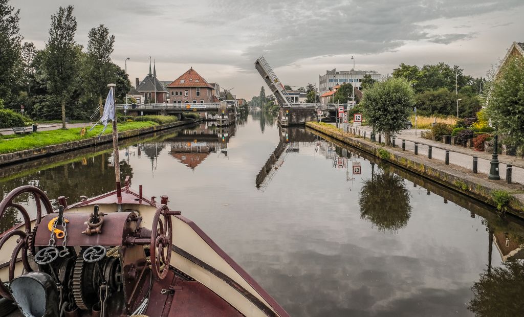 Vista di un canale con giardini e barche, Olanda