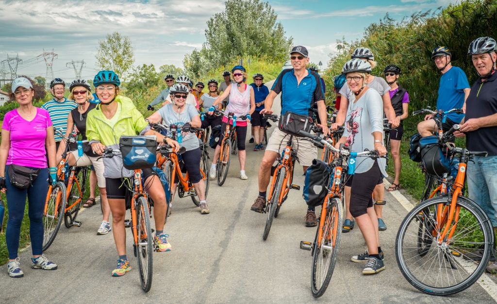 Gruppo di ciclisti in partenza lungo una pista ciclabile, tour cicloturistico in Italia con Girolibero.