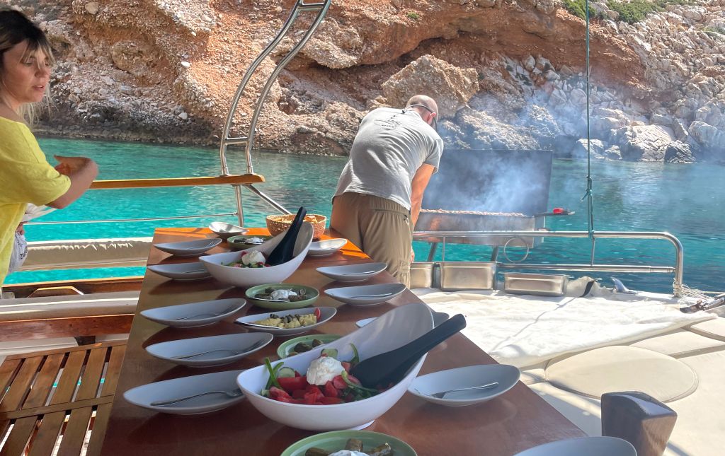 Tavolo preparato, pranzo in barca in baia con acque color smeraldo