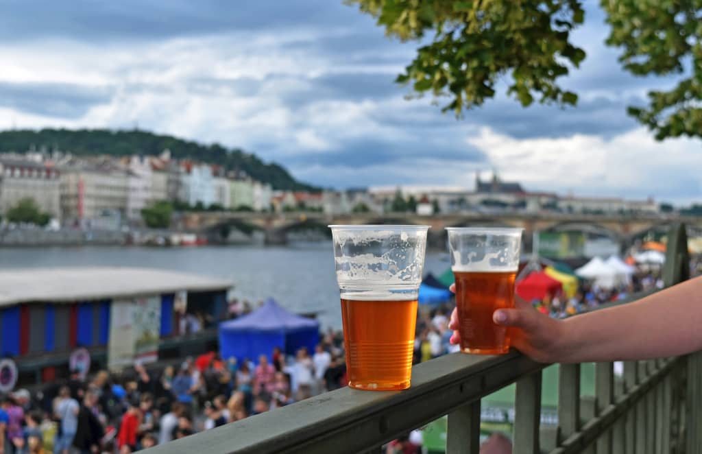 Bicchieri di birra ceca al festival Náplavka Beer sul lungofiume Moldava, atmosfera estiva a Praga