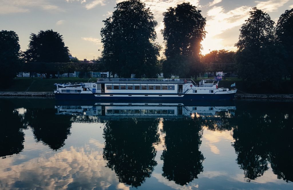 River cruise boat sailing at sunset along the Loire River, France.